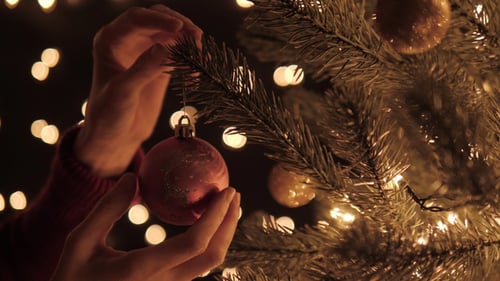 Decorating Christmas Tree at Night with Ornaments