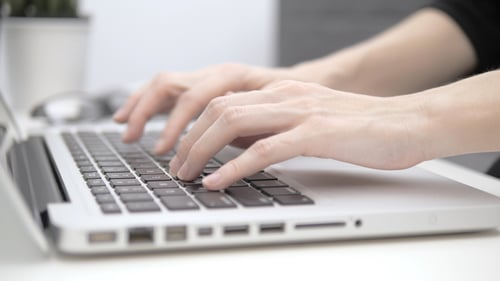 Hands Typing on Laptop Keyboard Close Up