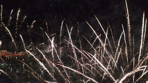 Aerial Fireworks Explode Over City at Night