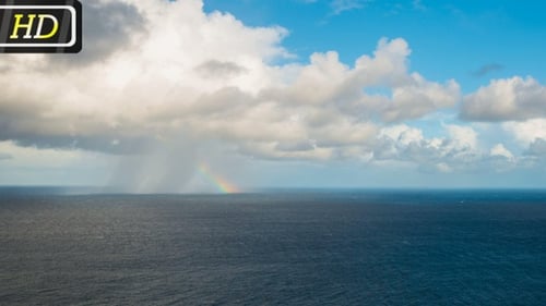 Regenwolke und Regenbogen über dem Meer