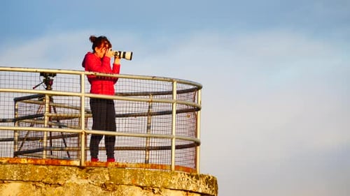 Woman Photographer on Seaside Lookout Taking Pictures