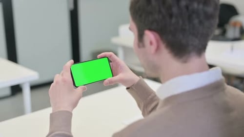 Rear View of Man Looking at Smartphone with Chroma Screen