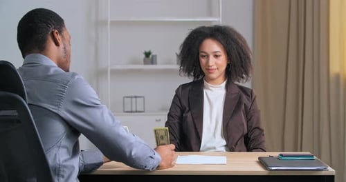 Woman Receives Cash From Man in Office