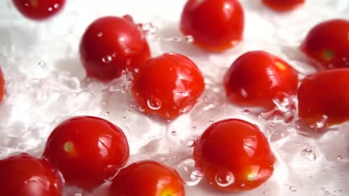 Rote Kirschtomate ins Wasser fallen.