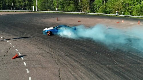 Blue Sports Car Drifting on Paved Race Track