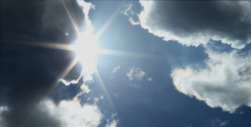Clouds Floating Across Blue Sky with Sunbeams