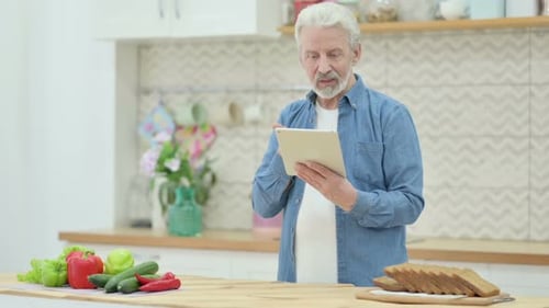 Senior Man Using Tablet in Bright Kitchen