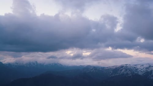 Snow Capped Mountains Under Moody Cloudy Sky