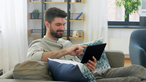 Smiling Man with Tablet Computer at Home