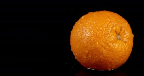 Auf einzelne orange fallende Wassertropfen mit einem Spritzer.