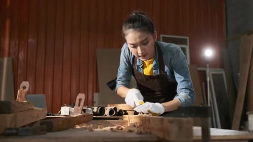 Woman Woodworker Chiseling Wood in Her Workshop