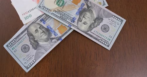 US Dollars and Chinese Yuan Bills Being Piled