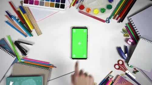 Set of 26 Gestures on Green Screen of the Smartphone Lying on White Table Among School Accessories