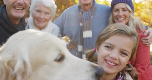 Family Smiling Together With Dog in Autumn Park