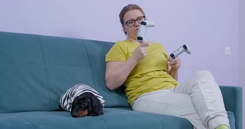 Woman With Dog Checks Video Game Controllers