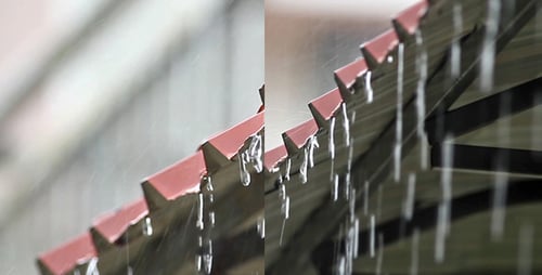 Rain Pouring off of Red Roof in Urban Area