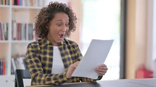 Woman Excitedly Reading Good News on Paper
