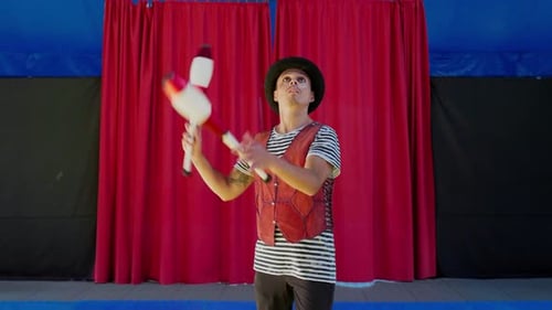 Zirkuskünstler jongliert mit Clubs in Manege