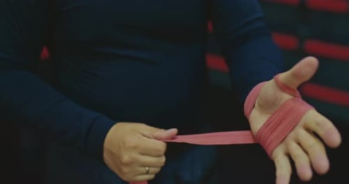 Athletic Man is Wrapping Hand Before Fight or Training in Fighting Club Closeup View Prores