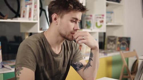 Attractive Sexy Programmer with Tattooes on His Arms Thinking Hard About Something