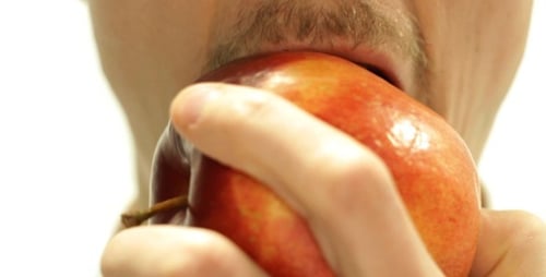 Male Biting A Juicy Ripe Apple Close Up