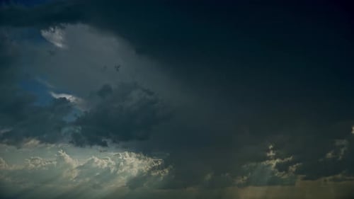 Los rayos del sol brillan a través de la tormenta oscura, cielo nublado y lluvioso con nubes de lluvia esponjosas
