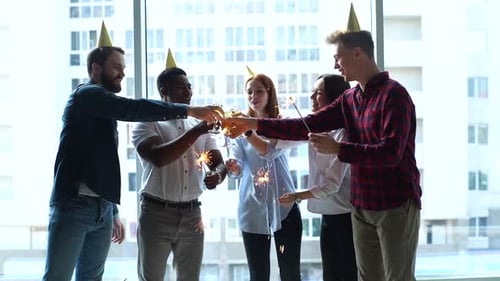 Retrato de uma jovem equipe empresarial bem-sucedida de funcionários multiétnicos segurando luzes de Bengala e