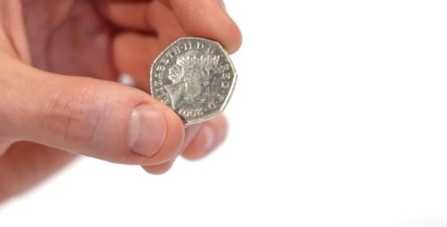 Male Hand Holding 50 Pence Coin