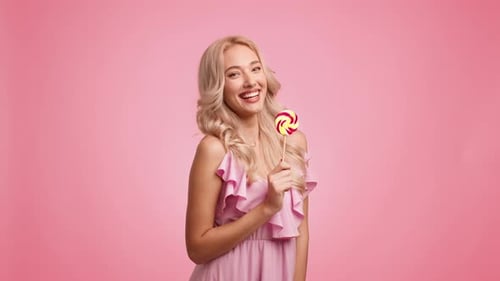 Smiling Woman with Lollipop in Pink Dress