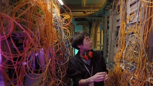 Technician Working in Server Room with Cables