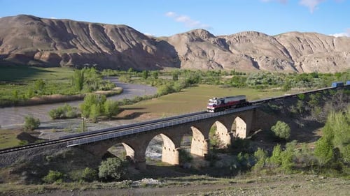 Train Crossing Stone Bridge in Rural Landscape