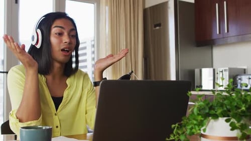 Young Adult Communicating Using Laptop and Headphones