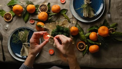 Setting Festive Holiday Table with Oranges and Candles