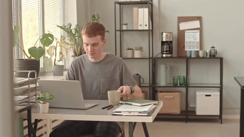 Mann arbeitet und trinkt Kaffee