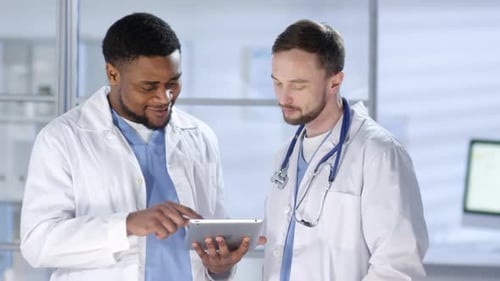Doctors Reviewing Digital Data on Tablet in Office
