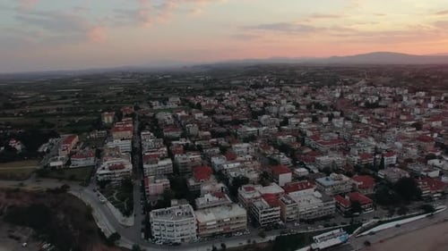 - Flying Over the Houses Rooftops in Coastal Town, Sunrise Scene. Nea Kallikratia, Greece