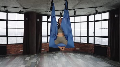 Woman Practicing Aerial Yoga in Studio Space