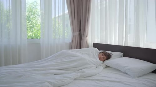 Un homme a froid dans un lit. Il essaie de s'échauffer sous la couverture. Concept de fièvre