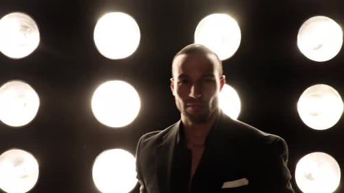 Handsome and stylish man in front of a wall of lights