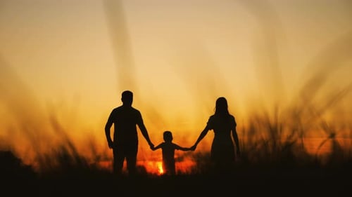 Family Silhouette Holding Hands at Golden Sunset