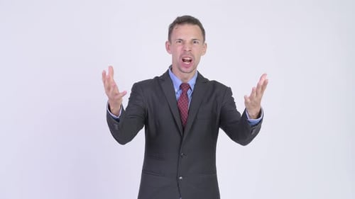 Studio Shot of Angry Businessman Talking To Camera