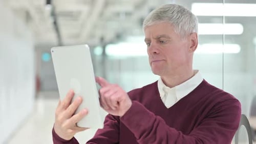 Focused Adult Uses Tablet in Modern Office