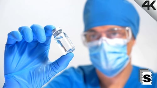 Doctor Holds Vial of Vaccine in Hospital Setting