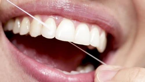 Nahaufnahme 4 k Video Frau lächelt und benutzt Zahnseide. Schönes sexy Lächeln, Lippen. natürlich