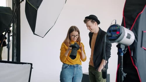 Model and Photographer Watching Photos on Camera After Photo Session in Studio