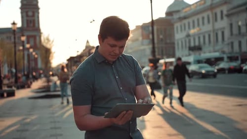 Young Caucasian Man Navigate in City Using Tablet Pc Computer