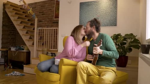 Vídeo auténtico de un hombre besando a su mujer embarazada en la sala de estar.