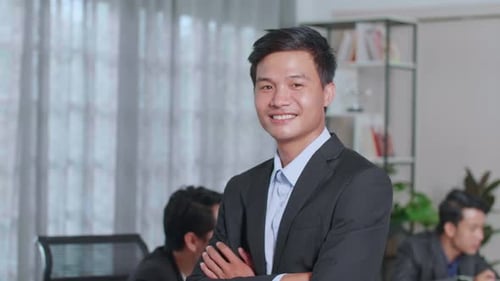 Portrait Of Young Asian Business Man Standing With Folded Arms At Office