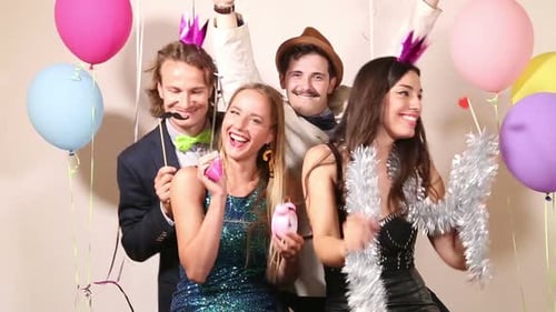 Group of friends making funny faces in party photo booth