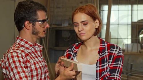 Male Carpenter Helping His Female Assistant at the Workshop